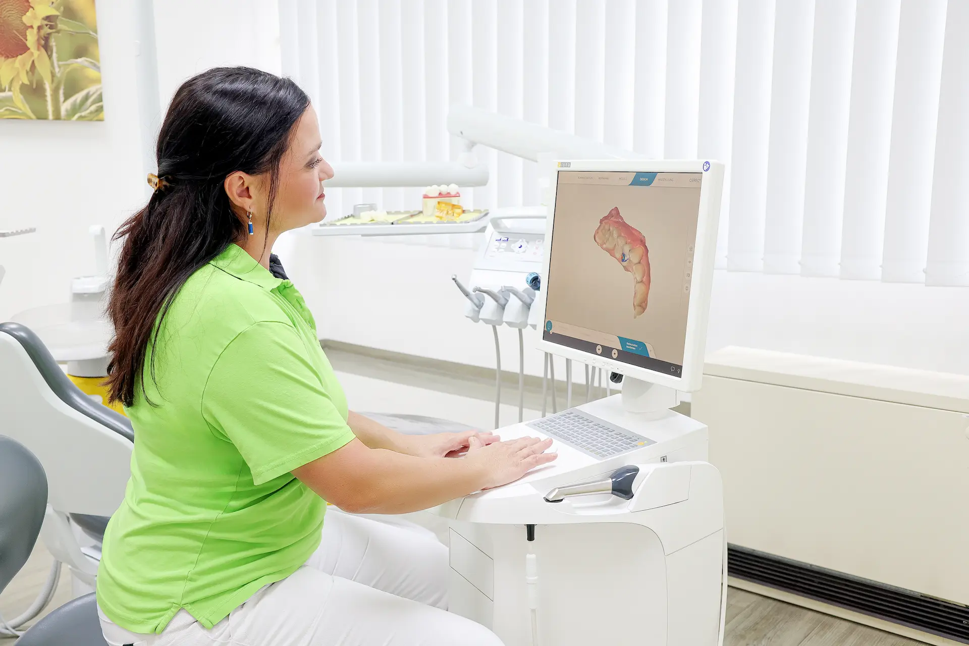 Zahnärztin betrachtet ein digitales 3D-Zahnmodell auf dem Bildschirm eines Intraoralscanners.
