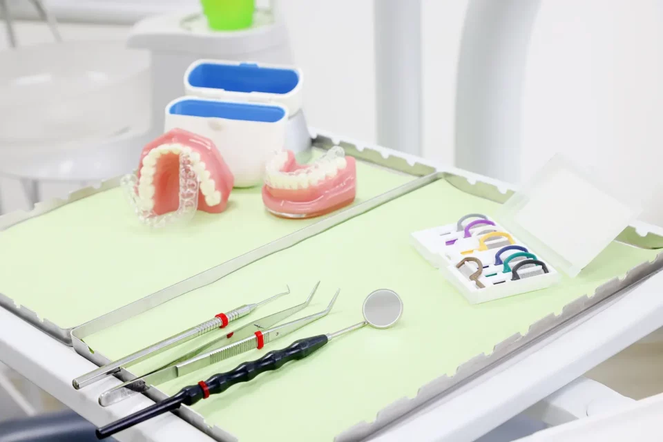 Zahnspangen, Zahnmodelle und Instrumente auf Tablett für Schienentherapie.